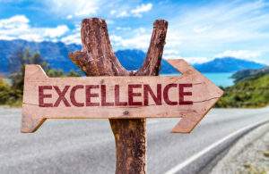 Picture of an "Excellence" sign on the side of a road.