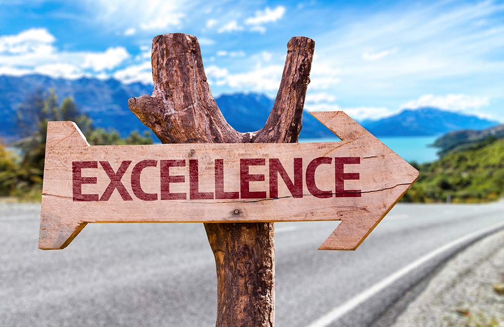 Picture of an "excellence" Sign on the Side of a Road.